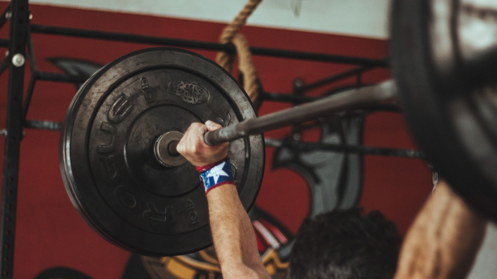 Athlete gripping a loaded barbell during strength training